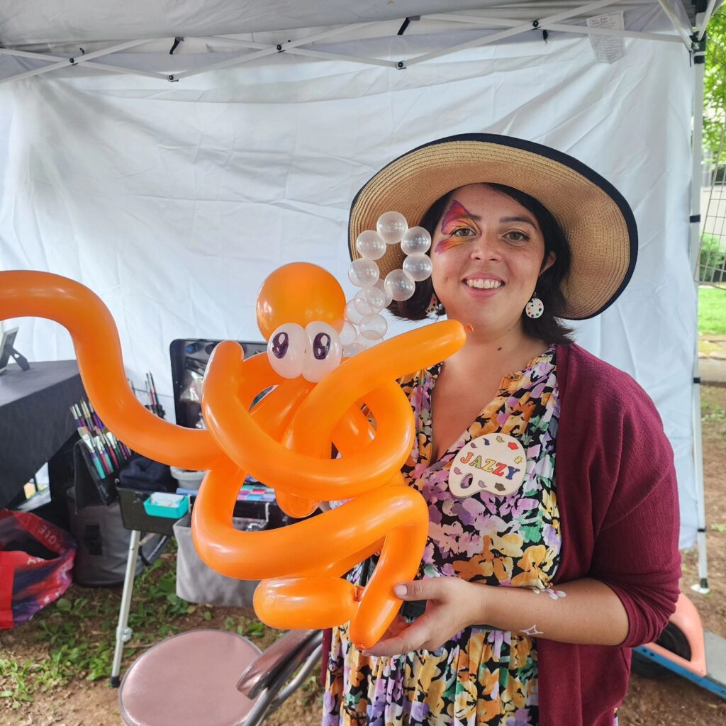 Lady with a hat showing a balloon animal