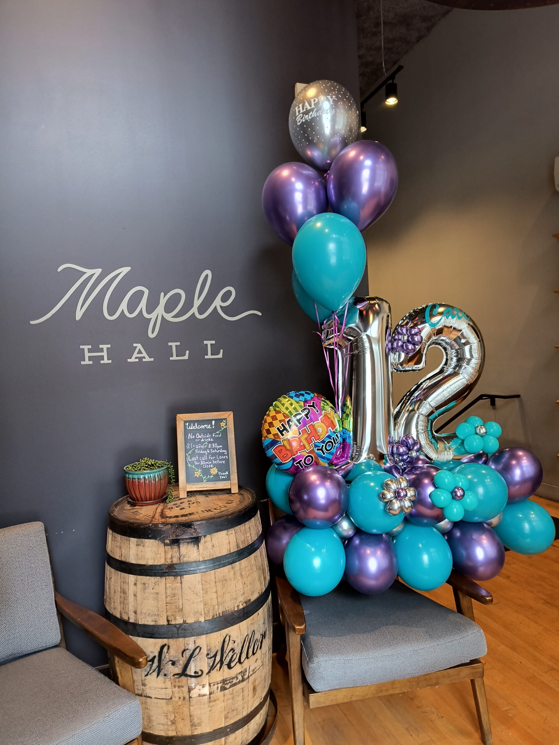 purple and teal balloon display for 12th birthday in front of the marble hall logo
